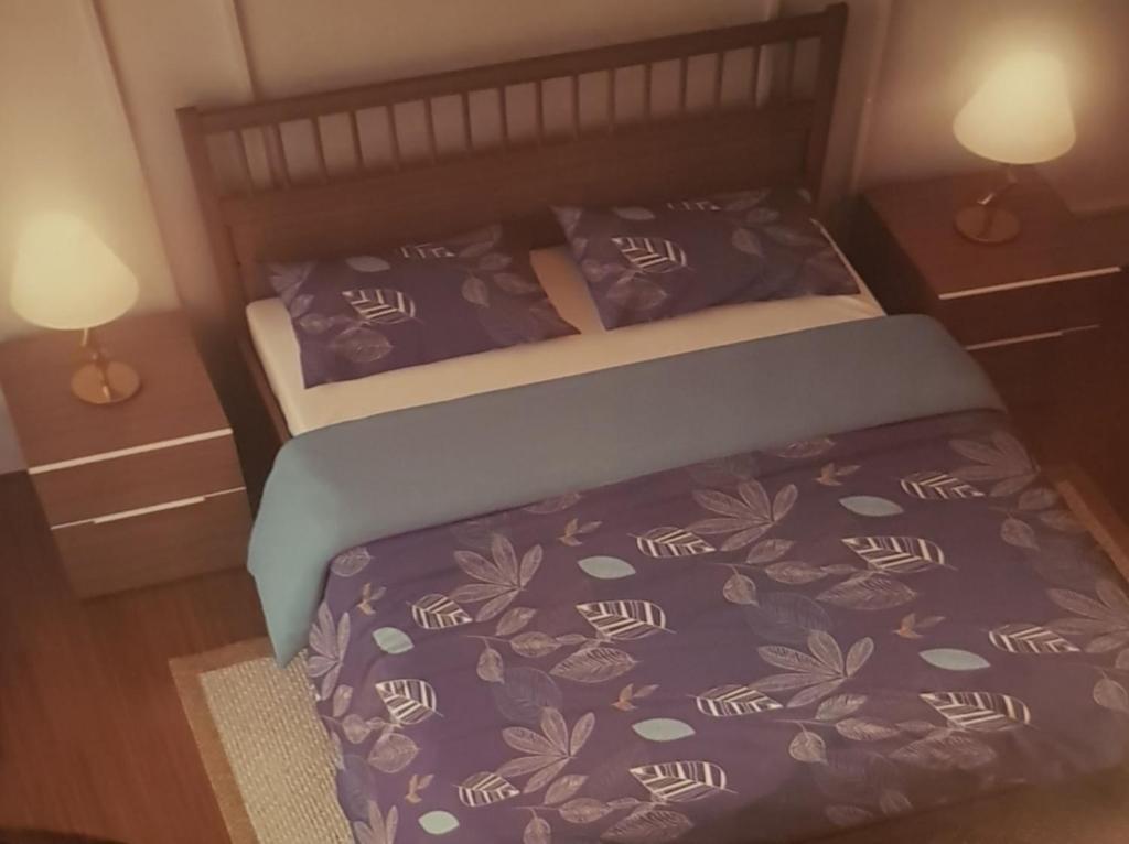a bedroom with two beds with purple sheets and pillows at Cozy Comfortable Room, in Wrocław