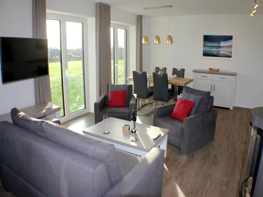 布特亞丁根的住宿－Ferienwohnung "Mien Dröm im Sielhuus"，客厅配有沙发、椅子和桌子