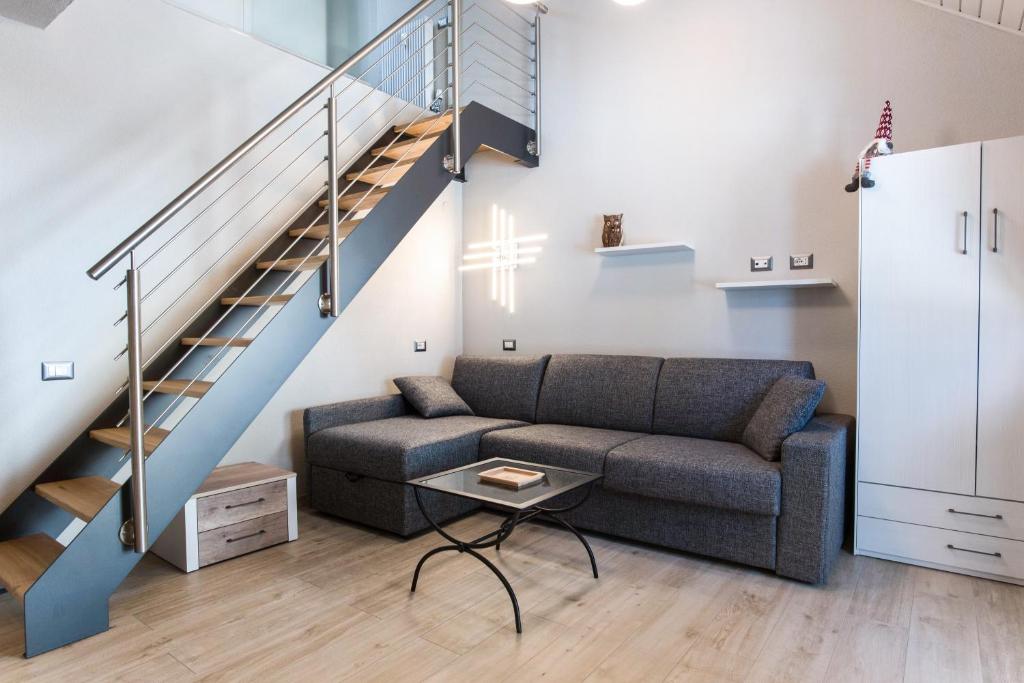 ein Wohnzimmer mit einem Sofa und einer Treppe in der Unterkunft Cesa Civetta in Canazei