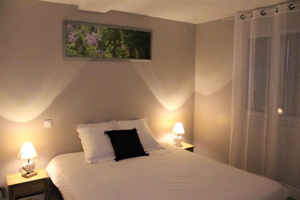 Un dormitorio con una cama con una almohada negra. en Dreams & Love in Sarlat 1 et 2, en Sarlat-la-Canéda