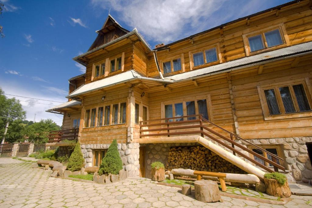 a large wooden house with a staircase in front of it at Pod Zielonym Bykiem in Witów
