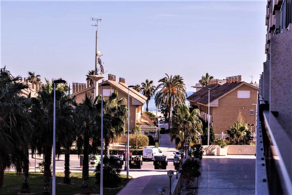 una calle de la ciudad con palmeras y un edificio en Marin Beach Apartments Patacona, en Valencia