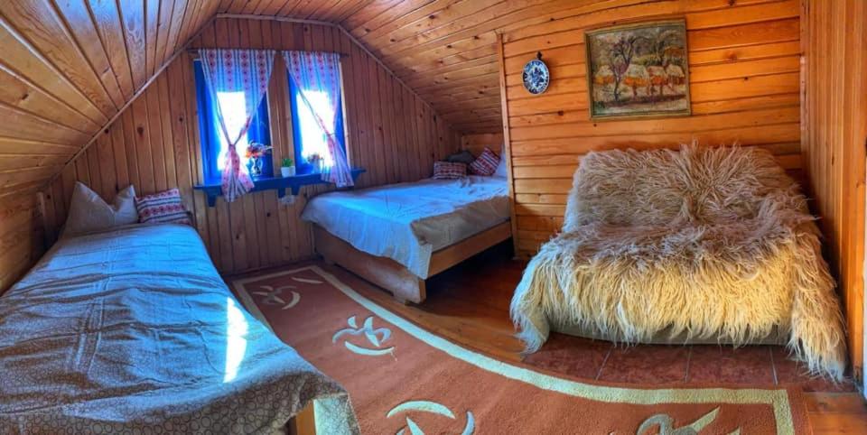 sypialnia z 2 łóżkami w drewnianym domku w obiekcie Căsuța Măriei w mieście Borşa