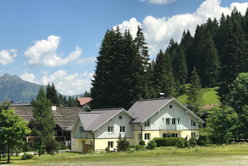 a large white house with trees in the background at Haus Capricorn - Garten Appartement in Gargellen