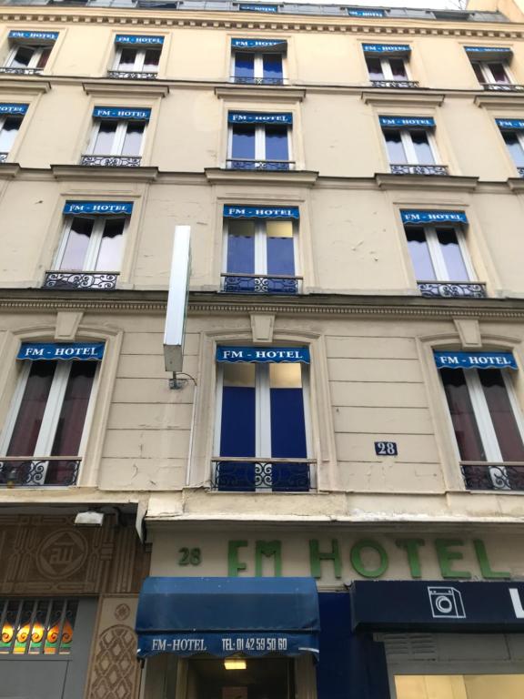 a building in paris with blue signs on it at FM Hotel in Paris