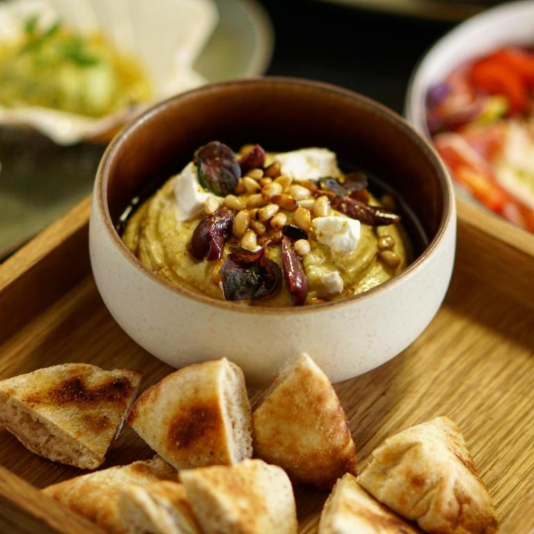 a bowl of hummus and some bread on a table at Hôtel le XIX in Béziers