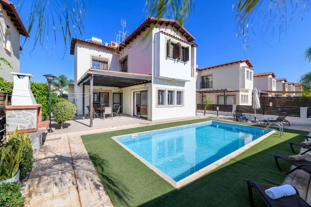 Villa con piscina frente a una casa en Villa Amaryllis, en Protaras