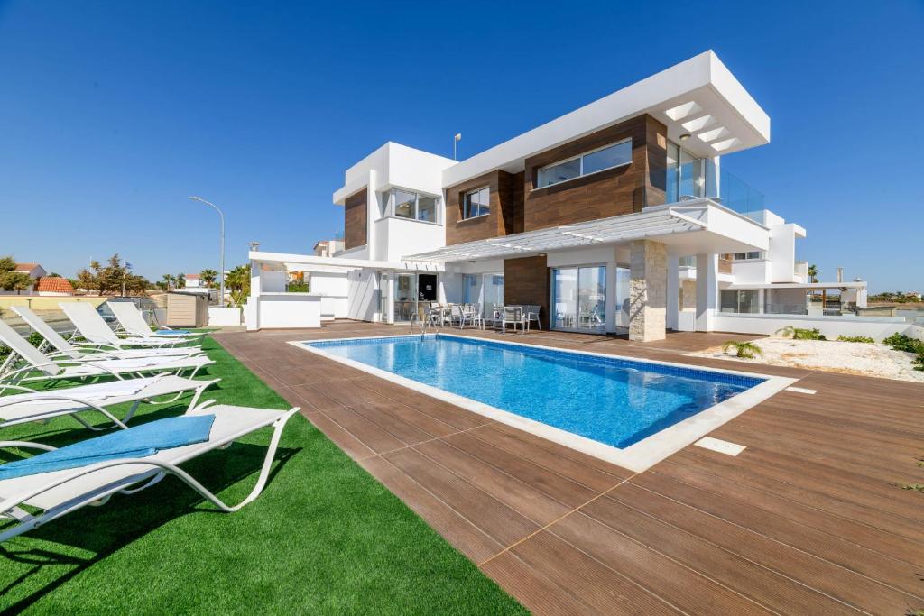 a villa with a swimming pool in front of a house at Infinity View Villa in Ayia Napa