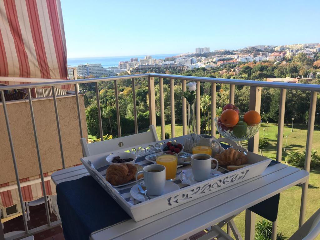 ein Tablett mit Speisen auf einem Tisch auf einem Balkon in der Unterkunft MiNERVA in Benalmádena