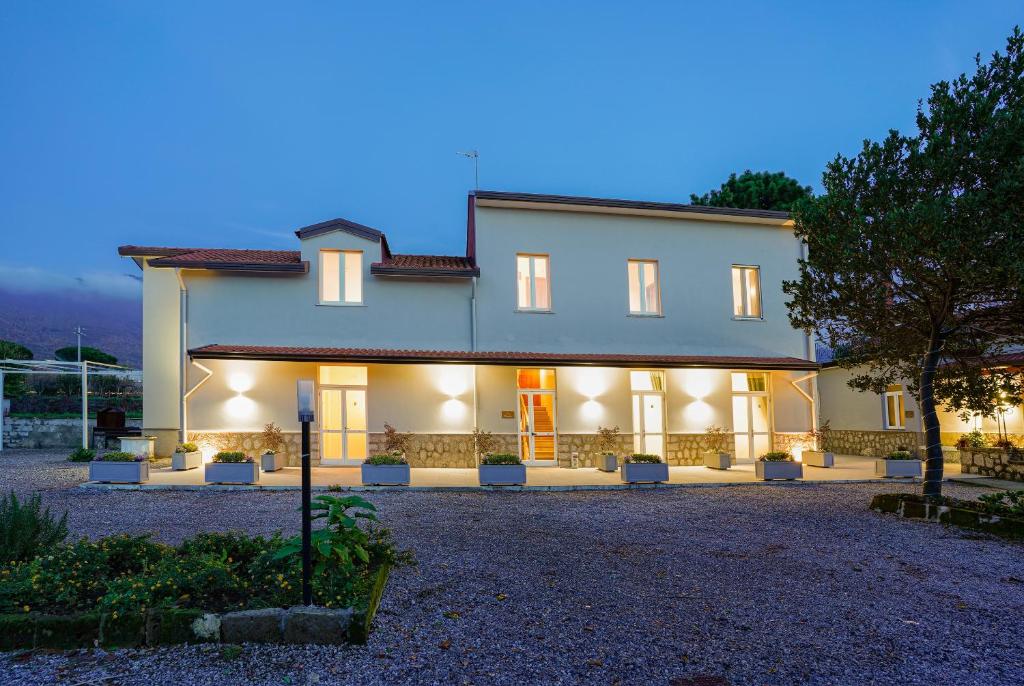 Une grande maison blanche éclairée dans l'établissement Cascina San Michele, à Fisciano