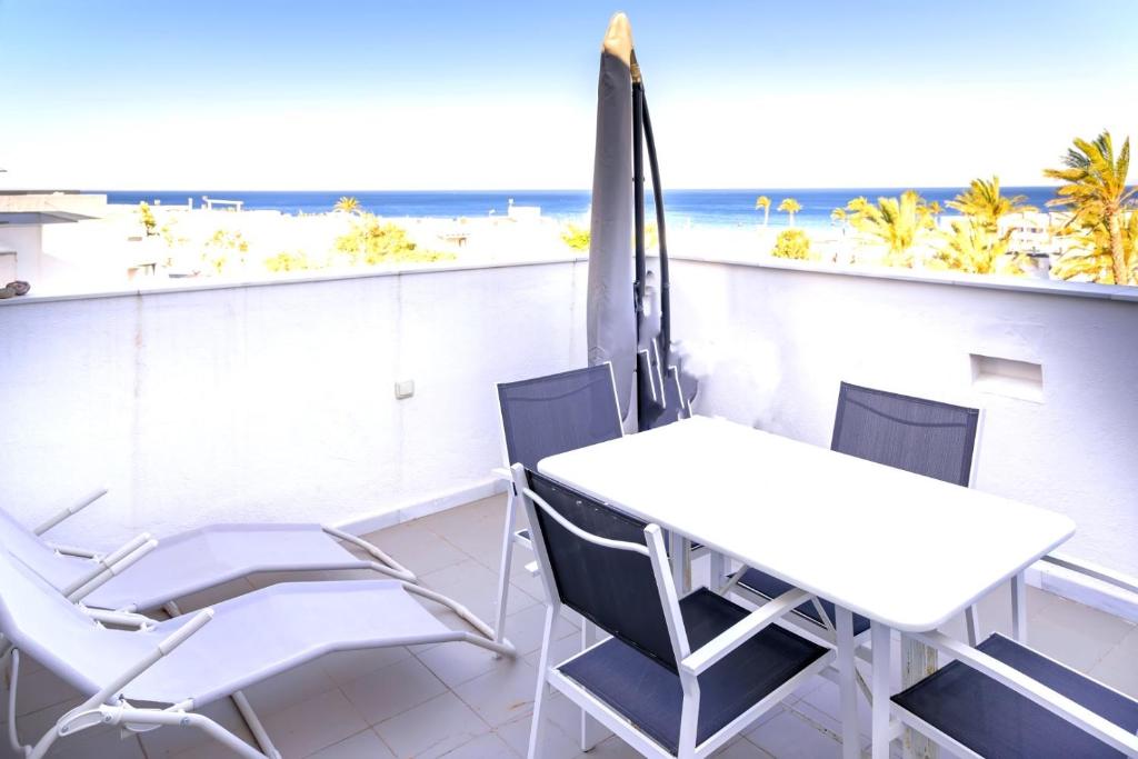 einen Tisch und Stühle auf einem Balkon mit Strandblick in der Unterkunft las negras-bergantin in Las Negras
