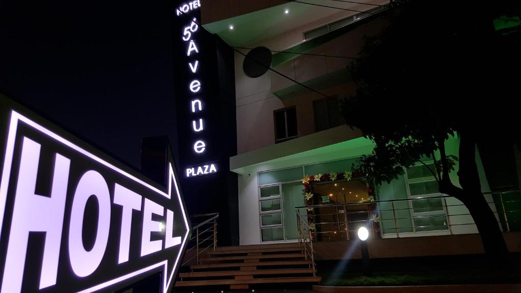 Hotel 56 Avenue Plaza في بارانكويلا: علامة الفندق امام مبنى في الليل