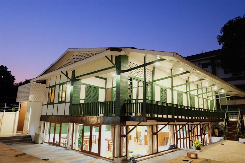 a house with a green and white facade at Barn Laos Hostel in Vientiane