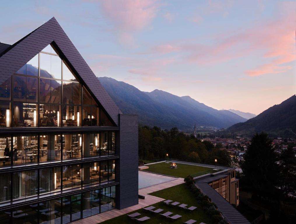 vista su un edificio con montagne sullo sfondo di Lefay Resort & SPA Dolomiti a Pinzolo