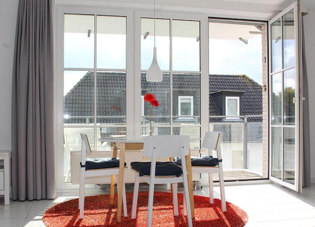 a dining room with a table and chairs and a large window at Apartmentvermittlung Mehr als Meer - Objekt 18 in Niendorf