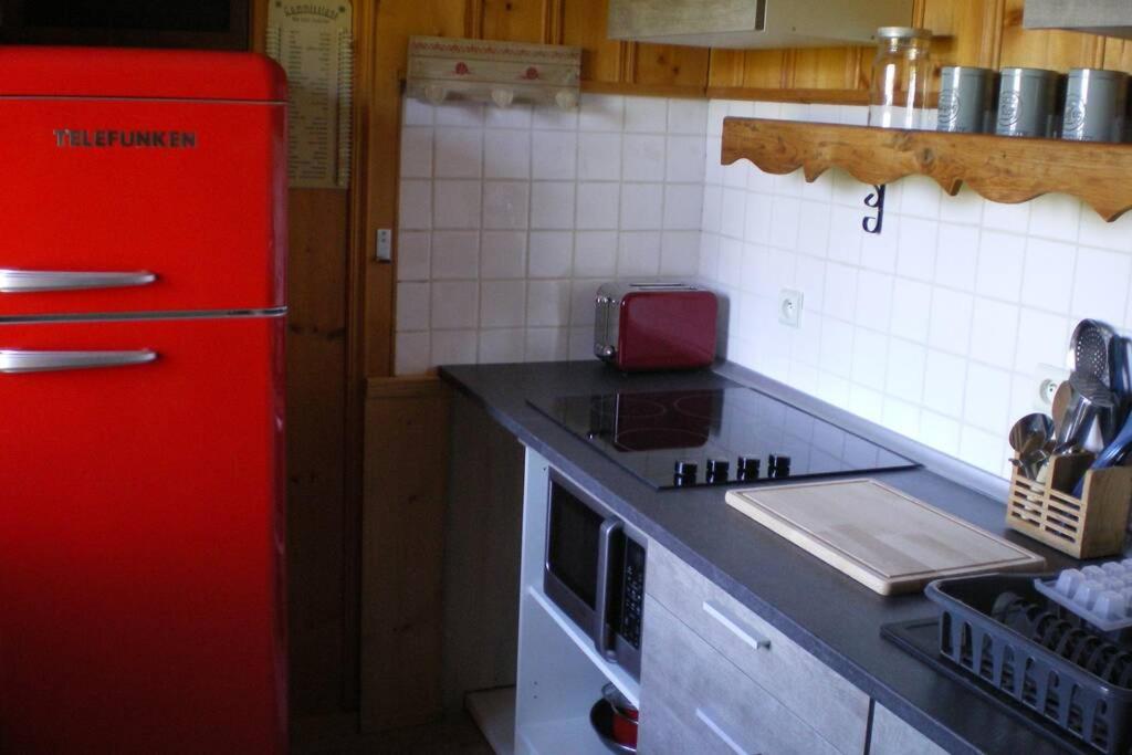 een keuken met een rode koelkast en een fornuis bij L Ermitage ST Roch appartement ST André in Salins-les-Bains