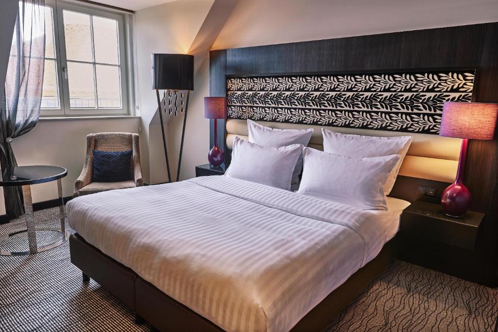 Postel nebo postele na pokoji v ubytování Steigenberger Icon Grandhotel Handelshof Leipzig