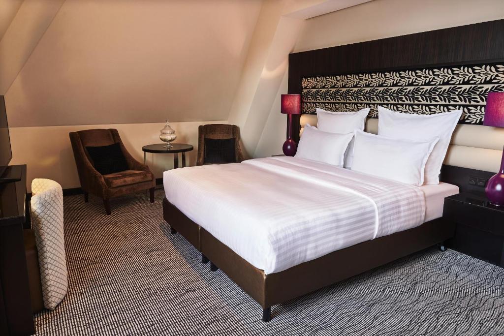 Postel nebo postele na pokoji v ubytování Steigenberger Icon Grandhotel Handelshof Leipzig