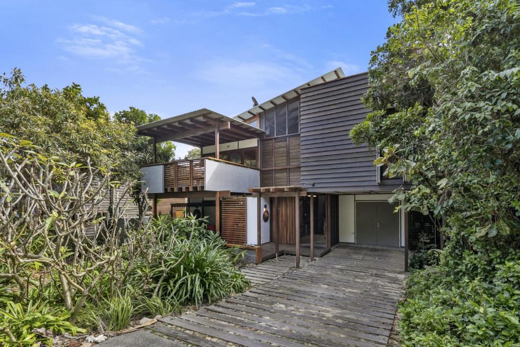 a house with a wooden walkway leading up to it at Pandanus Retreat in Point Lookout