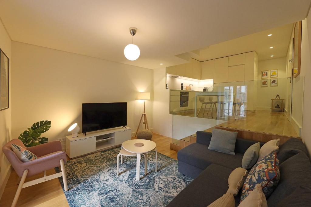 a living room with a couch and a tv at FLH Porto Spacious Duplex in Porto