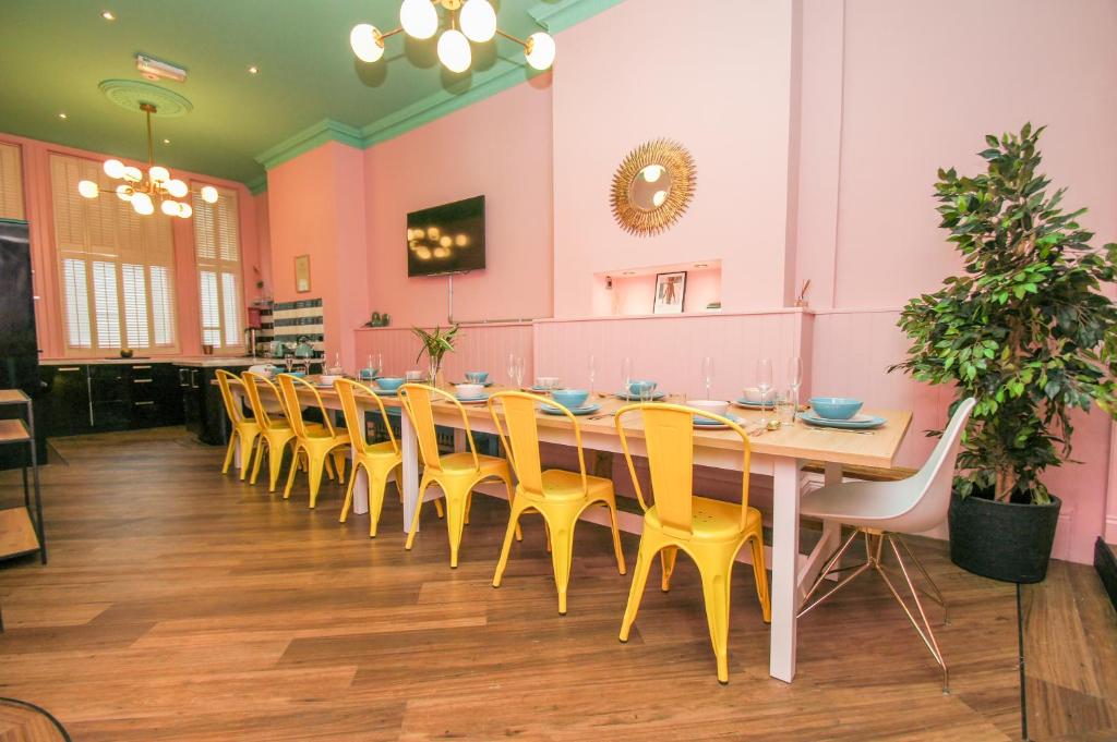 une grande salle à manger avec une grande table et des chaises jaunes dans l'établissement Brighton Lanes Townhouse, à Brighton et Hove