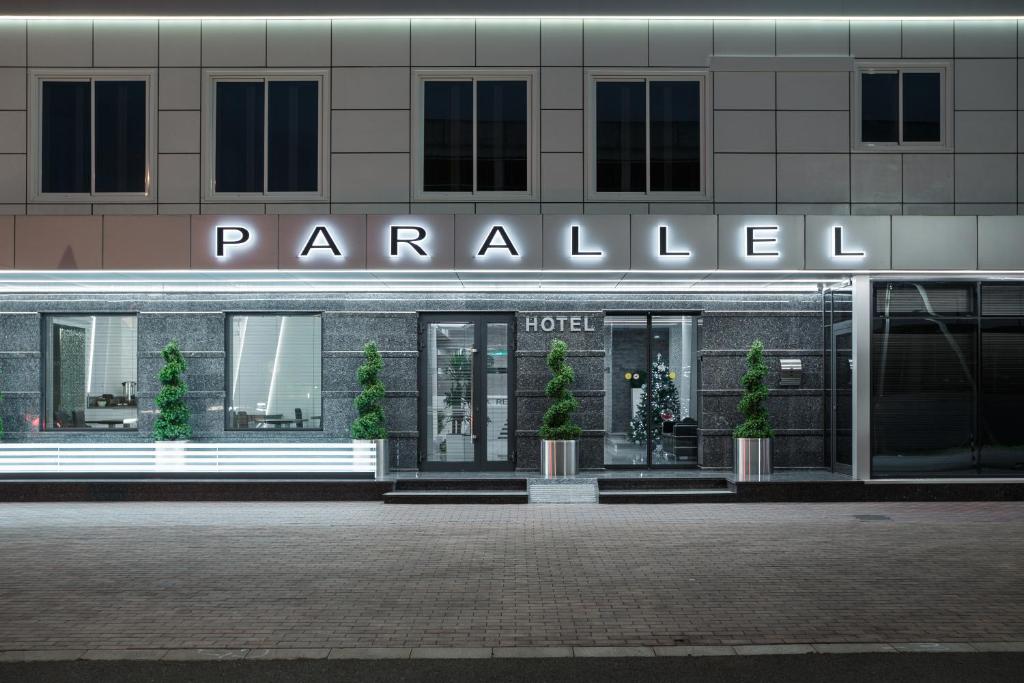 a hotel with a sign on the front of it at Parallel Hotel & Conference Krasnodar in Krasnodar