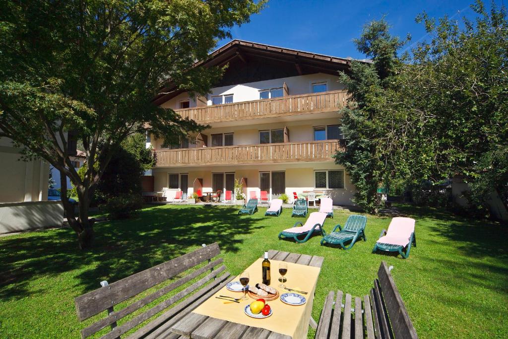 une table et des chaises devant un bâtiment dans l'établissement Alpina Residence, à Naturno