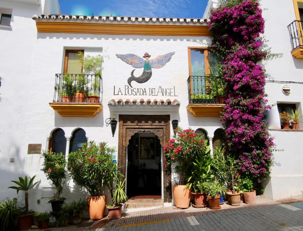 ein Gebäude mit Blumen davor in der Unterkunft Boutique Hotel La Posada del Angel Ojén in Ojén