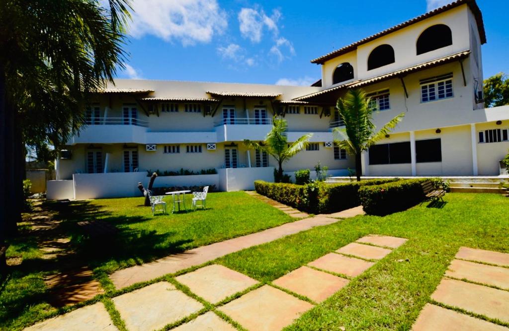 uma casa com um relvado em frente em Pousada Aruana Praia em Aracaju