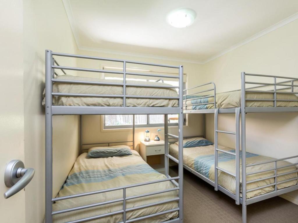 two bunk beds in a small room with a window at At Melaleuca 3 in Point Lookout
