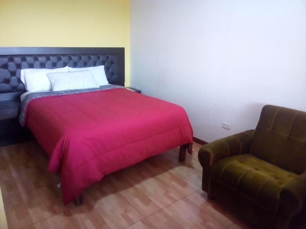 a bedroom with a bed, chair and a lamp at Misti Hostel B&B in Arequipa
