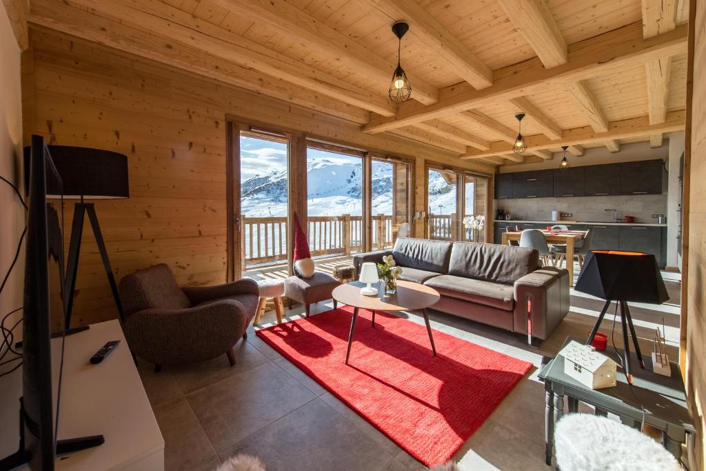 ein Wohnzimmer mit einem Sofa und einem Tisch in der Unterkunft ODYSSEE B301 Duplex mansarde sur les pistes, vue panoramique in La Toussuire