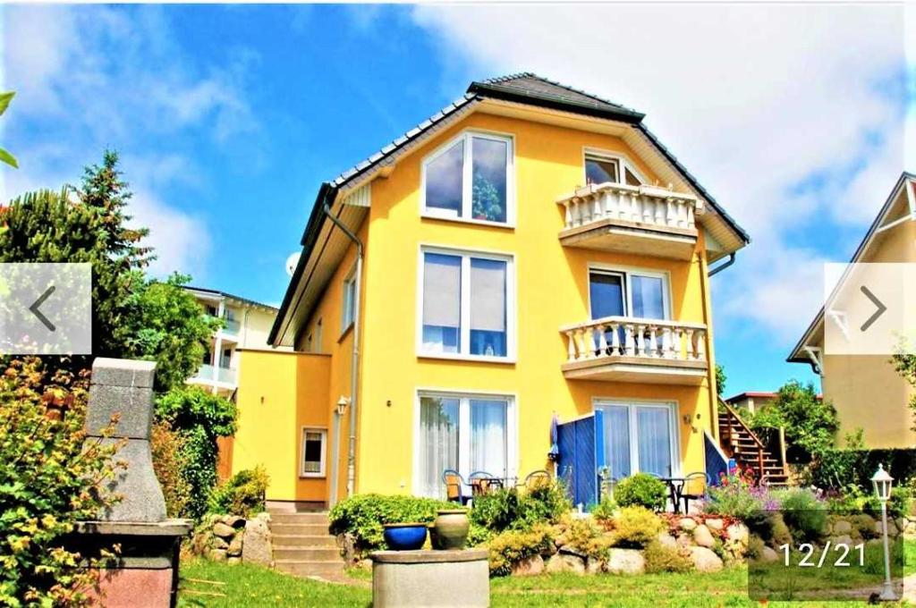 ゲーレンにあるFerienwohnungen Haus Inselblick miの黄色の家 バルコニー付