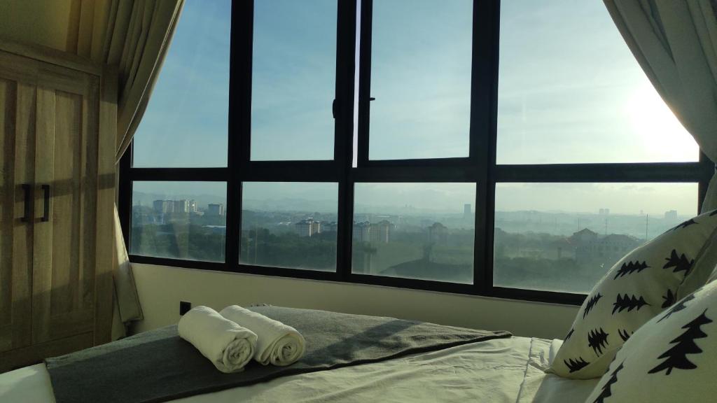 a bedroom with two towels on a bed in front of a window at Conezion Luxury 3BR for 7pax @IOI Resort Putrajaya in Putrajaya