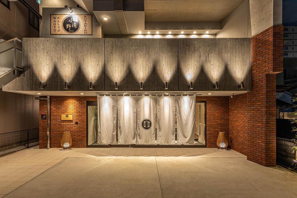 una pista de baile vacía en una habitación con una pared de ladrillo en PROSTYLE RYOKAN TOKYO ASAKUSA en Tokio