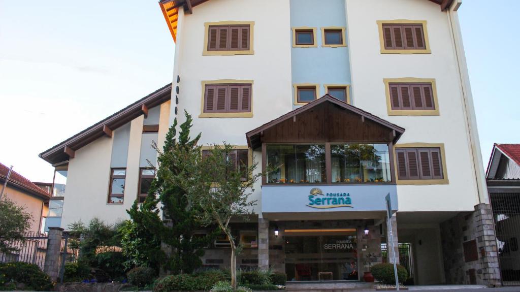 a tall white building with a sign on it at Pousada Serrana in Nova Petrópolis