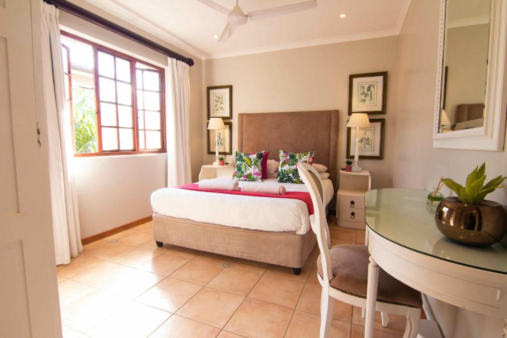 a bedroom with a bed and a glass table at 12 On Oyster in Durban