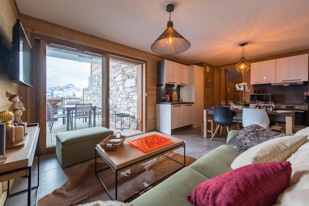 ODYSSEE ERJ01 Appartement avec terrasse et acces aux pistes في لا توسوير: غرفة معيشة مع أريكة وطاولة