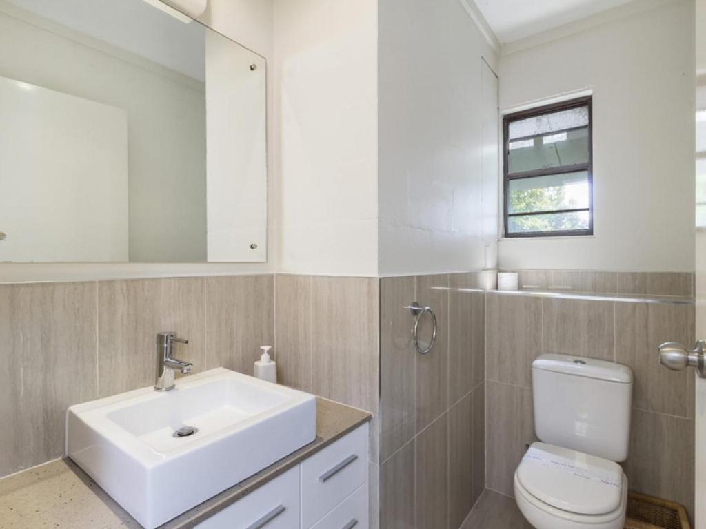 a bathroom with a sink and a toilet and a mirror at Acutterbove in Point Lookout
