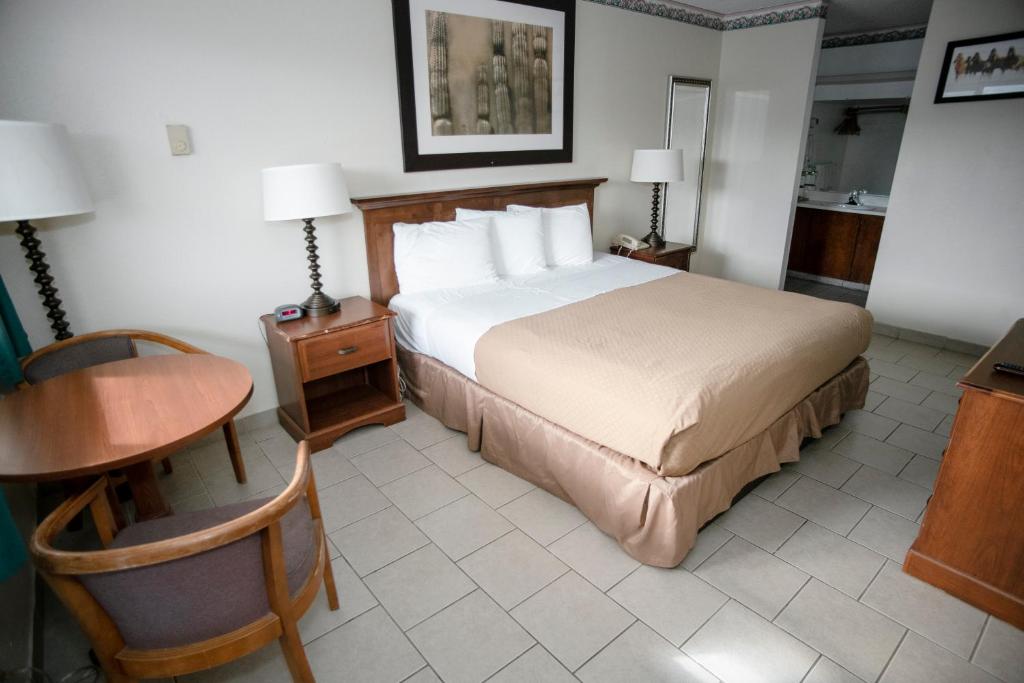 ein Hotelzimmer mit einem Bett, einem Tisch und einem Schreibtisch in der Unterkunft Pacific Inn in Crescent City