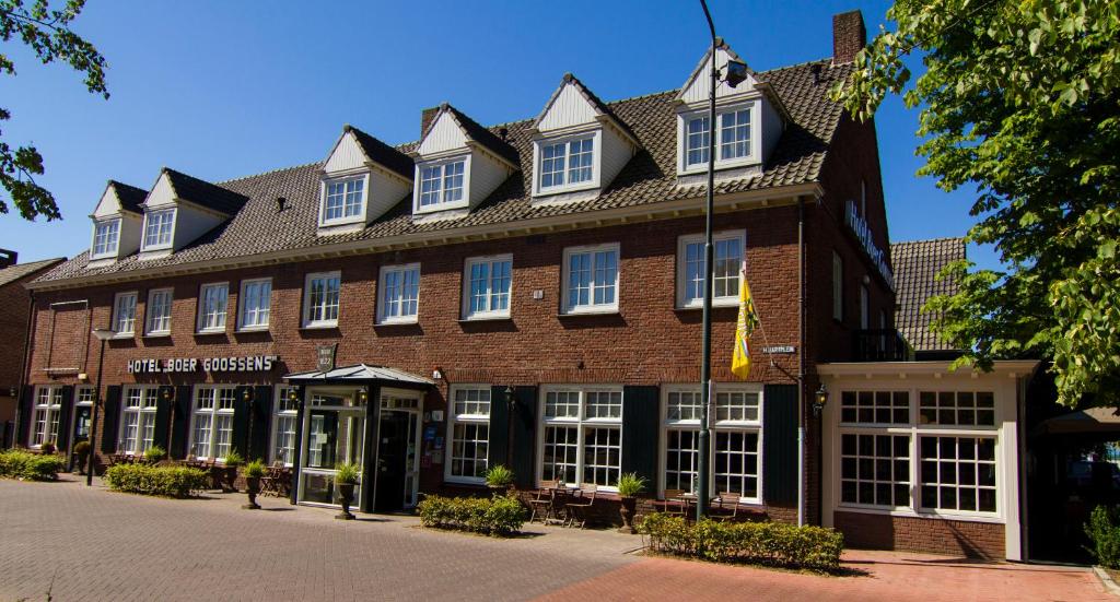 a large red brick building with white windows at Hotel Boer Goossens in Den Dungen