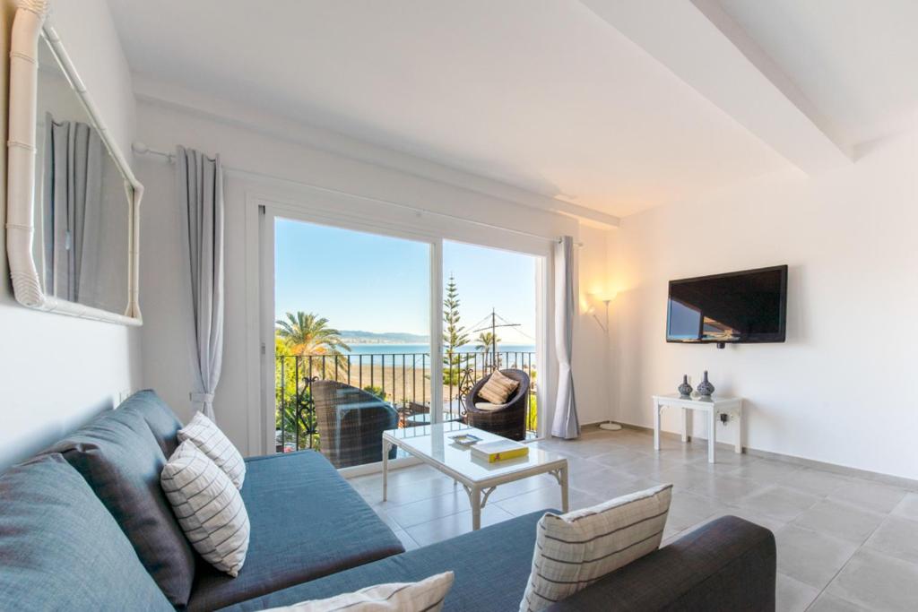 a living room with a blue couch and a view of the ocean at Puerto Banus Frontline Apartment with Amazing Sea Views in Marbella