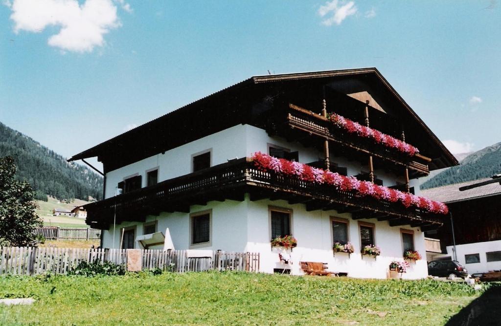 a house with flowers on the top of it at Pension Rainhof in Santa Maddalena