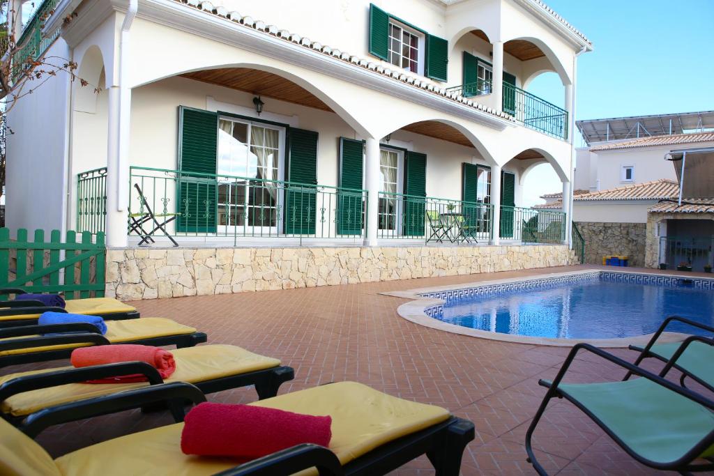 une terrasse avec des chaises longues et une piscine dans l'établissement Casa Sousa, à Lagos