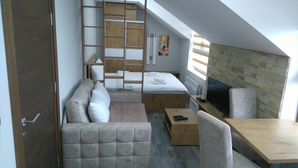 een woonkamer met een bed, een bank en een tafel bij Milmari, Resort, Apartman Premier 52 in Kopaonik