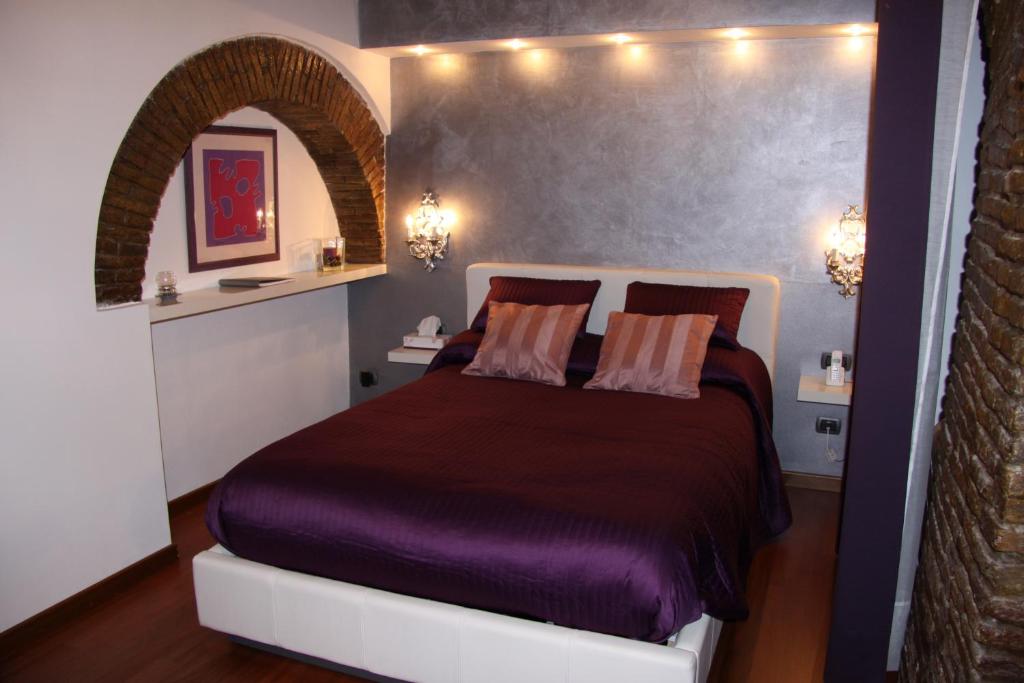 a bedroom with a purple bed with lights on the wall at Domus31 - Luxury House in Trastevere in Rome