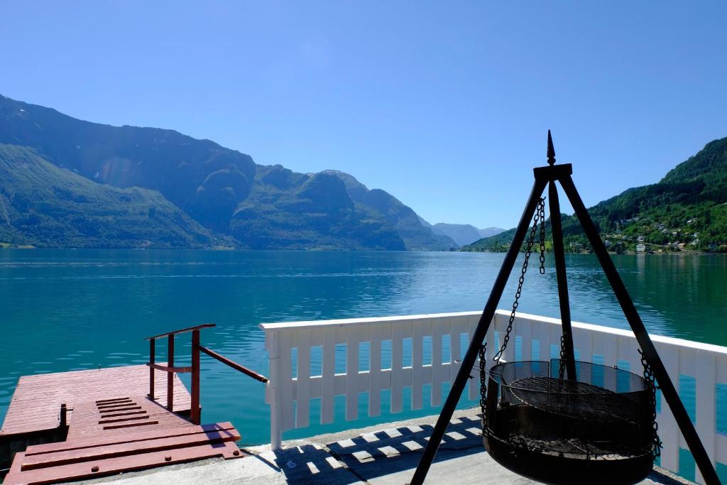 une balançoire assise sur un quai à côté d'un lac dans l'établissement Dalsøren Camping og hytter, à Luster