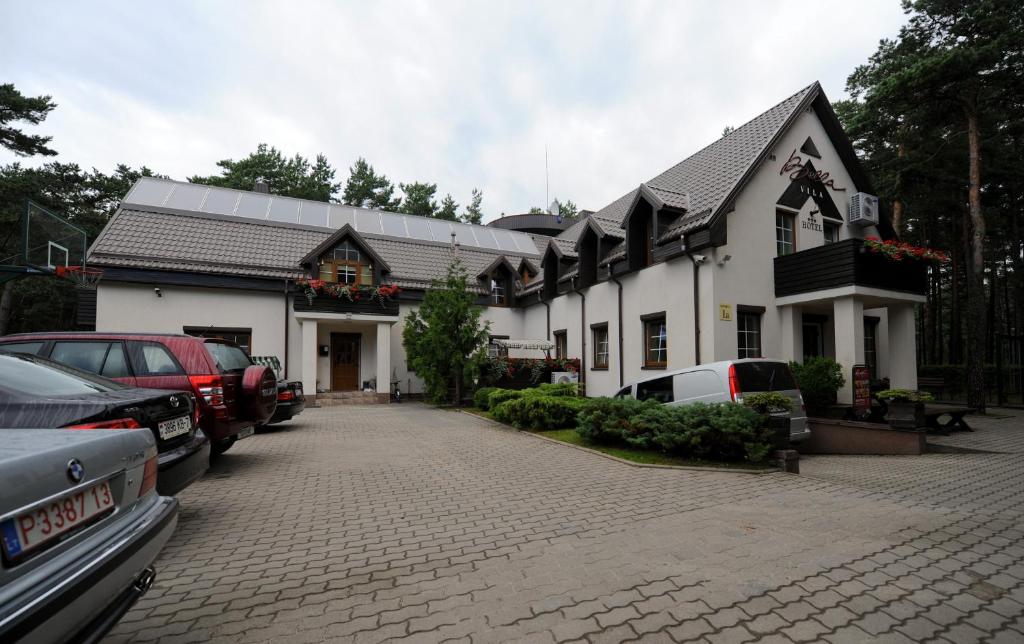 un edificio blanco con coches estacionados frente a él en Bella Vila, en Palanga