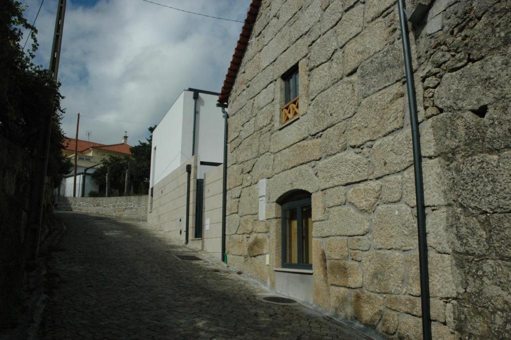 a stone building with a window on a street at Casa Da Canada in Seia