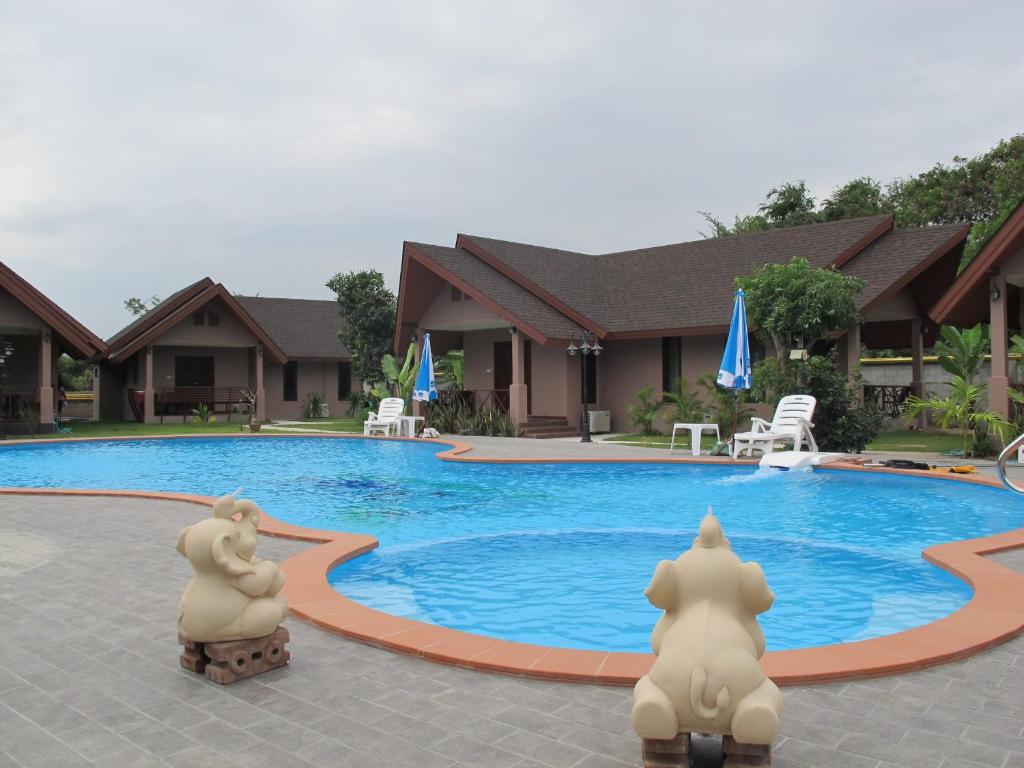 una piscina con dos estatuas frente a un edificio en La-or Resort, en Hua Hin